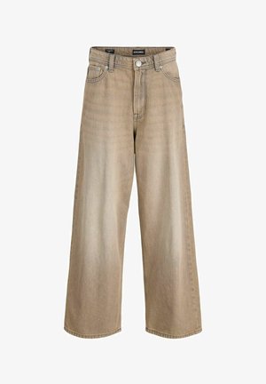 Czarna bawełniana koszulka z białymi akcentami, z napisem "ORIGINALS studio", zestawiona z beżowymi spodniami o szerokich nogawkach i neutralnymi trampkami.