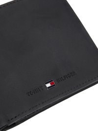 Portofel din piele neagră cu logo-ul embosat "TOMMY HILFIGER" și accente rectangulare de culoare bloc în roșu, alb și albastru. Design plat cu margini cusute.