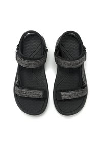 Sandales noires avec une semelle en caoutchouc texturé, motif en nid d'abeille et sangles réglables avec une touche de tissu gris. Design léger et flexible.