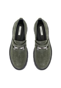 Grüne Wildleder-Loafer mit schwarzen Gummisohlen, ausgestattet mit einem silbernen Schnallenakzent und gestickten Details entlang der Kanten.