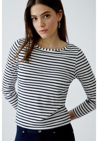 Langärmliges Oberteil in weiß mit marineblauen horizontalen Streifen, runder Ausschnitt, weiche Textur, taillierte Passform und glatte Oberfläche.