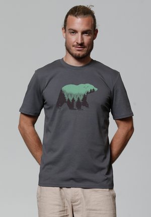 Grijze katoenen t-shirt met een grafisch ontwerp van een beer met groene bomen. Korte mouwen en ronde hals. Glad textuur, losse pasvorm.