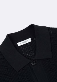Polo shirt nera in maglia con un motivo testurizzato, colletto e chiusura con bottoni. L'etichetta recita "Paolo Pecora Milano."