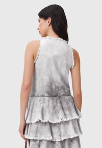 Vestido de mezclilla gris con bordes deshilachados, diseño de volantes en capas y parte superior ajustada. Textura suave con un efecto ombré de claro a oscuro.