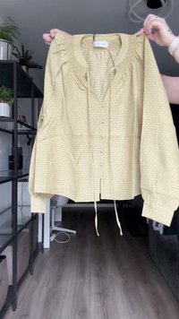 Soe heledast kollane, pika varrukaga pluus tekstuurse mustriga, kokku kogutud õlgadega, nööbid sulgemiseks ja lipsud detailideks ääres.