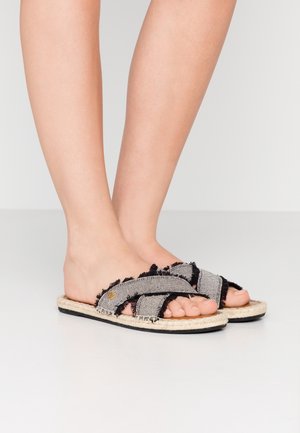 Sandales ouvertes à bout, avec un tissu rayé noir et gris aux bords effilochés, une garniture en jute et une semelle noire plate.