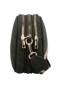 Mørkegrøn taske med tre gyldne lynlåse, en nøglekæde-klip og et camouflage-stofrem med fastgjort lædermærke.