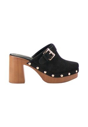 Zueco de ante negro con tacón de bloque de madera, correa con hebilla plateada y tachuelas plateadas a lo largo del borde de la suela, vista lateral sobre fondo blanco.