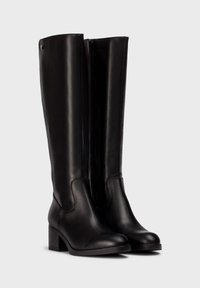 Botas negras hasta la rodilla, confeccionadas en cuero suave, con punta redonda, tacón cuadrado y cremallera lateral para ponerlas y quitarlas fácilmente.