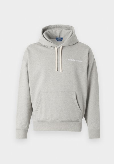 Svetlo siva kapuca iz mehkega materiala, z sprednjim žepom, vrvicami in belim logotipom na prsih. Klasičen, sproščen kroj.