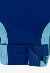Bodysuit en coton bleu avec des finitions en bleu clair. Équipé de pressions en bas pour un habillage facile. Texture douce, tissu côtelé.