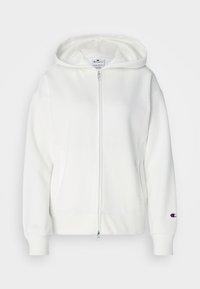Sudadera blanca con cremallera, capucha con cordón, puños y dobladillo acanalados. Presenta un pequeño logotipo bordado en la manga izquierda. Textura suave y lisa.