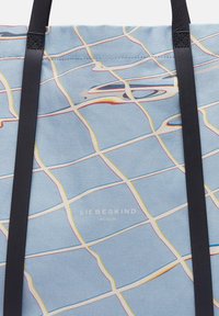 Blau canvas schoudertas met een ruitenpatroon in gele, rode en zwarte lijnen. Voorzien van zwarte leren banden en de tekst "LIEBESKIND BERLIN" in het midden.