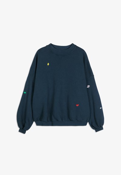 Marinblå sweatshirt med lösa ärmar och små färgglada symboler av spelkortssuiter broderade på framsidan och ärmarna.