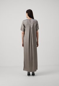 Rochie lungă din satin taupe, cu mâneci scurte, un decolteu în formă de cheia pe spate și o croială lejeră. Textură netedă și design până la podea.