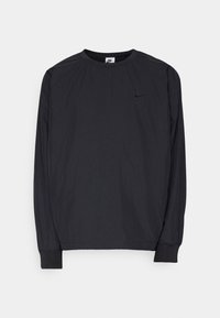 Black long-sleeve Nike shirt featuring a crew neck, elastic cuffs, and a small, embossed logo on the left chest. Smooth fabric texture.