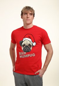 Camiseta de algodón roja con un gráfico de un pug usando un sombrero de Papá Noel y el texto "BAH HUMBUG" en letras grandes y de color claro.