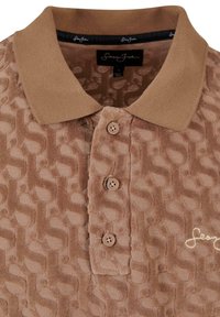 Polo marron texturé avec trois boutons, col contrastant et logo brodé sur la poitrine.