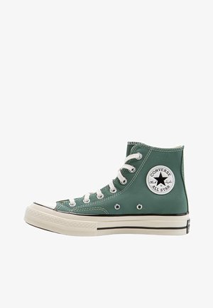 Zielony wysoki sneaker Converse All Star z białymi sznurowadłami, gumową podeszwą i naszywką z logo na kostce.