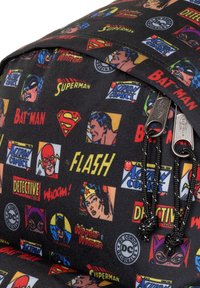 Mochila de tela negra con un estampado colorido de personajes de cómic, que incluye logotipos y rostros, con cierres de cordón y acentos metálicos.
