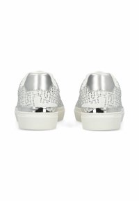 Baskets blanches avec une tige argentée texturée, des accents métalliques au talon et ornées de petits clous. Semelle en caoutchouc avec une finition lisse.