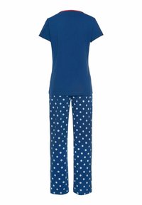 Blaues Baumwolloberteil mit kurzen Ärmeln und rotem Kragen; passende blaue Hose mit großen weißen Punkten, entspannter Schnitt.