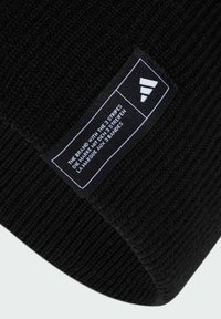 Zwarte gebreide beanie met ribbeltextuur. Inclusief een rechthoekig label met witte tekst en een logo met drie strepen.