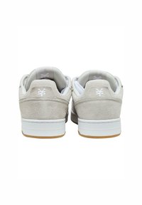 Suede sneakers in light gray with white details. Low-profile design, padded collar, and a gum rubber outsole for traction.