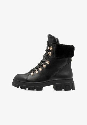 Black leather ankle boots with a thick rubber sole, faux fur collar, and metallic lacing hardware. Features a rugged design and textured surface.