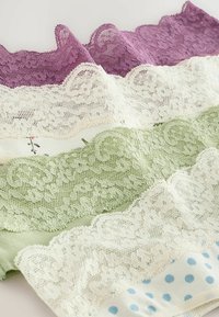 Tyglappar med spetskant i lila, gräddvit, grön och blå med prickar, som visar texturerade mönster och varierande spetsmönster.