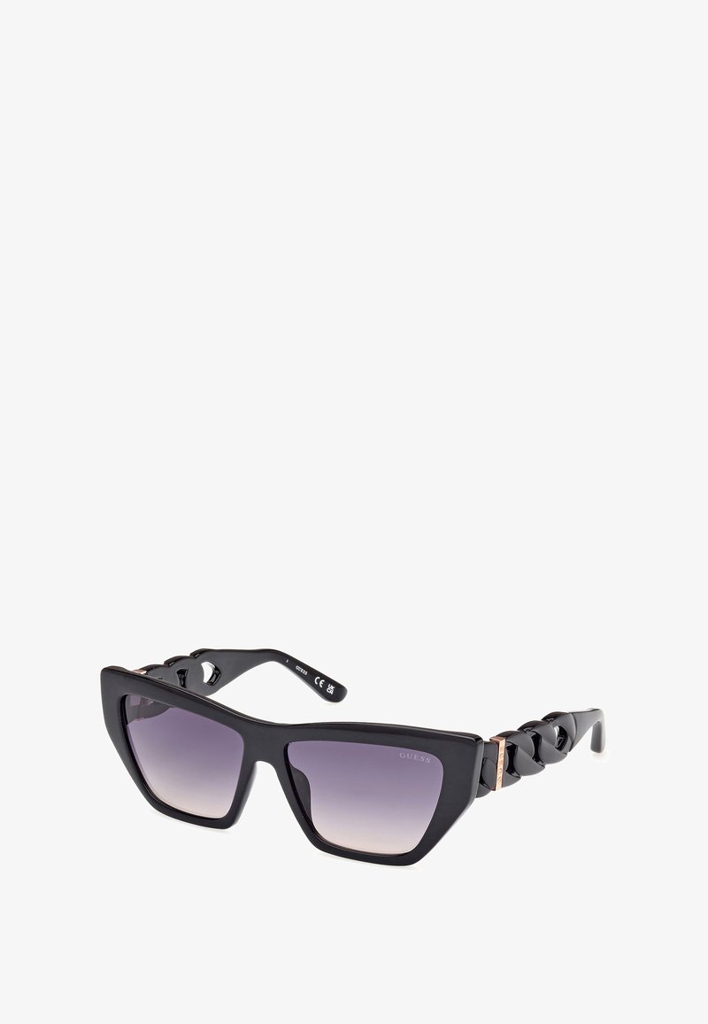 Gafas de sol negras con forma geométrica de ojo de gato, lentes morados degradados, acentos de temple con textura de cadena y un acabado brillante.