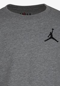 Gray cotton t-shirt with a crew neckline, featuring a black Air Jordan logo on the left chest area. Soft texture with a slight heather pattern.