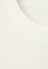 Krémově zbarvený pletený svetr s žebrovanou texturou a kulatým výstřihem, představující jemné vrstvení a detaily z měkké látky.