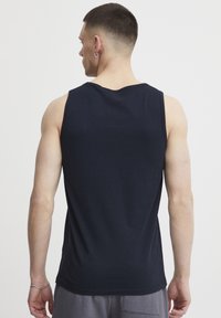 Navyblaues Tanktop aus Baumwolle, mit rundem Halsausschnitt und ärmellosem Design. Glatte Textur mit entspannter Passform.