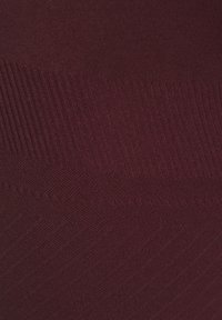 Burgundy knit fabric with varying textures, featuring ribbed patterns and smooth sections. Soft material with an even color distribution.