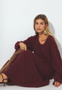 Bordeaux neulemekko, jossa on rento malli, leveät hihat ja pyöreä pääntie. Liu'uttava tuntuma, yltää polven puoliväliin ja sopii ruskeiden asusteiden kanssa.