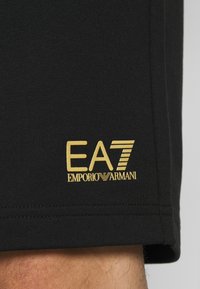 EA7 Emporio Armani BERMUDA - Pantalones deportivos - black/gold-coloured