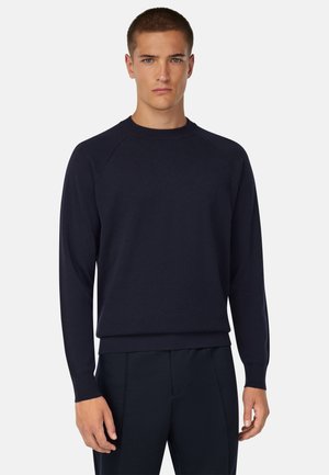 Marineblauer Rundhalsausschnitt-Pullover aus weichem Stoff, mit gerippten Bündchen und Saum. Eng geschnitten mit Raglanärmel für bequeme Bewegungen.