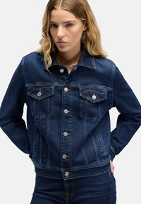 Kurtka jeansowa w średnim odcieniu niebieskiego, wyposażona w klasyczny kołnierz, zapinana na guziki, z dwoma kieszeniami na piersi i ozdobnymi przeszyciami. Teksturowany, casualowy design.