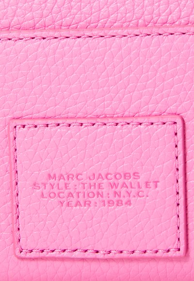 Roosa nahast rahakott tekstureeritud viimistlusega. Silmapaistvad reljeefsed brändingu ja detailid sisaldavad "Marc Jacobs," stiili, asukohta ja aastat.