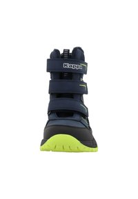 Zilā un melnā sporta apavu pāris ar trim Velcro siksnām, ar teksturētu augšdaļu un spilgti zaļu gumijas zoli. Iezīmēts ar logotipu un akcentiem limonādē zaļā krāsā.