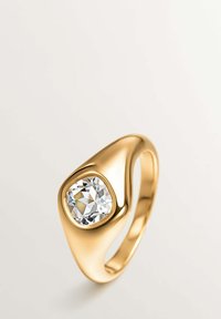 Anillo de oro con un prominente diamante claro facetado, engastado en una banda de forma orgánica y suave con un acabado pulido.