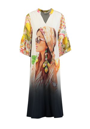 Długa sukienka z dekoltem w serek, szerokimi rękawami w kwiatowy wzór, gradientem kolorów od białego do czarnego oraz dużym namalowanym na przodzie wizerunkiem kobiety w okularach przeciwsłonecznych i kolczykach.