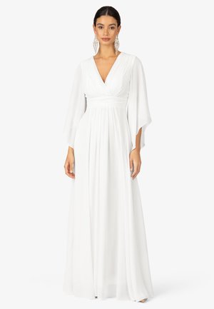 Long white dress with a wrap V-neck, flowing sleeves, and gathered waist. Made from lightweight material, features a floor-length design.