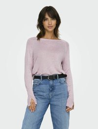 Lichtroze langemouwen top met een boot halslijn en geribbelde details, gedragen met hoge taille blauwe jeans en een zwarte riem met een zilveren gesp.
