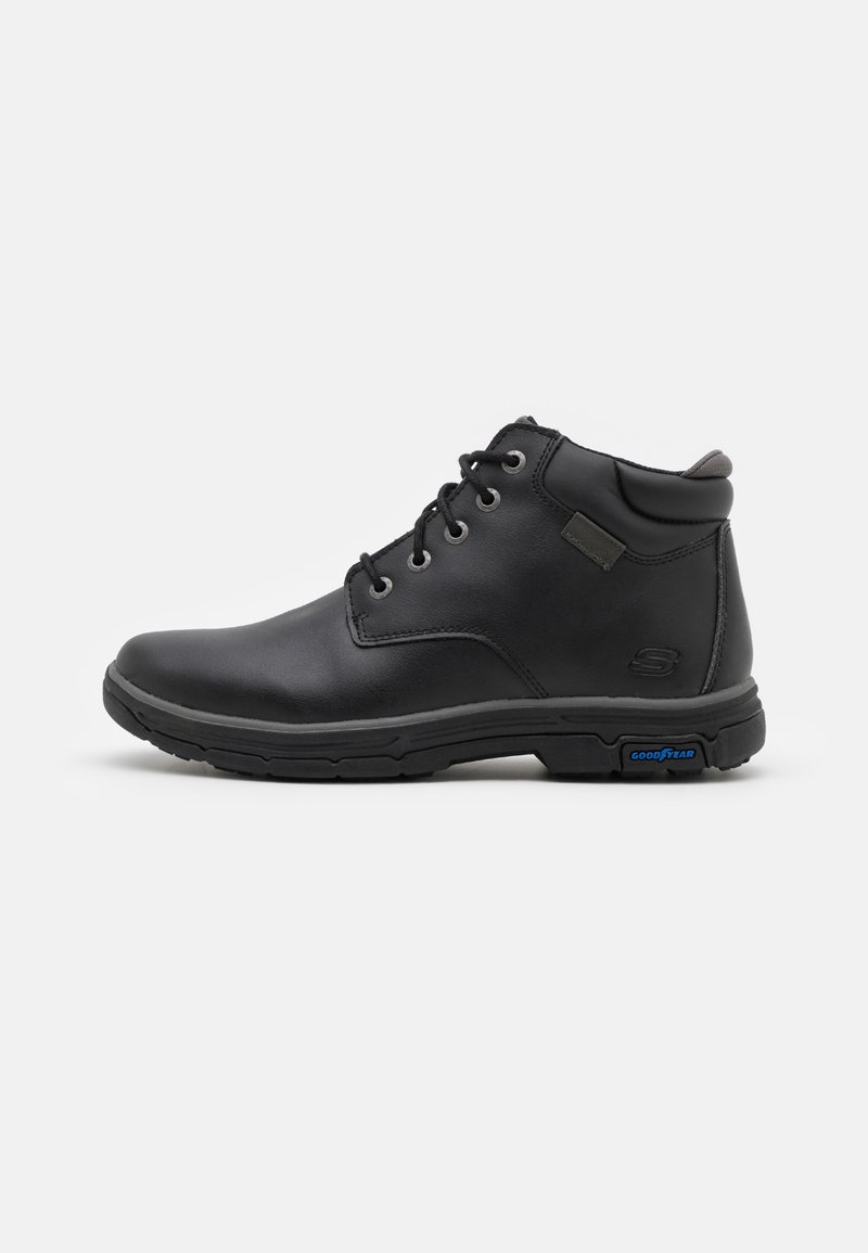 Black leather ankle boots with lace-up design, padded collar, and rubber outsole. Features emblem detailing and gray accents on the tongue.
