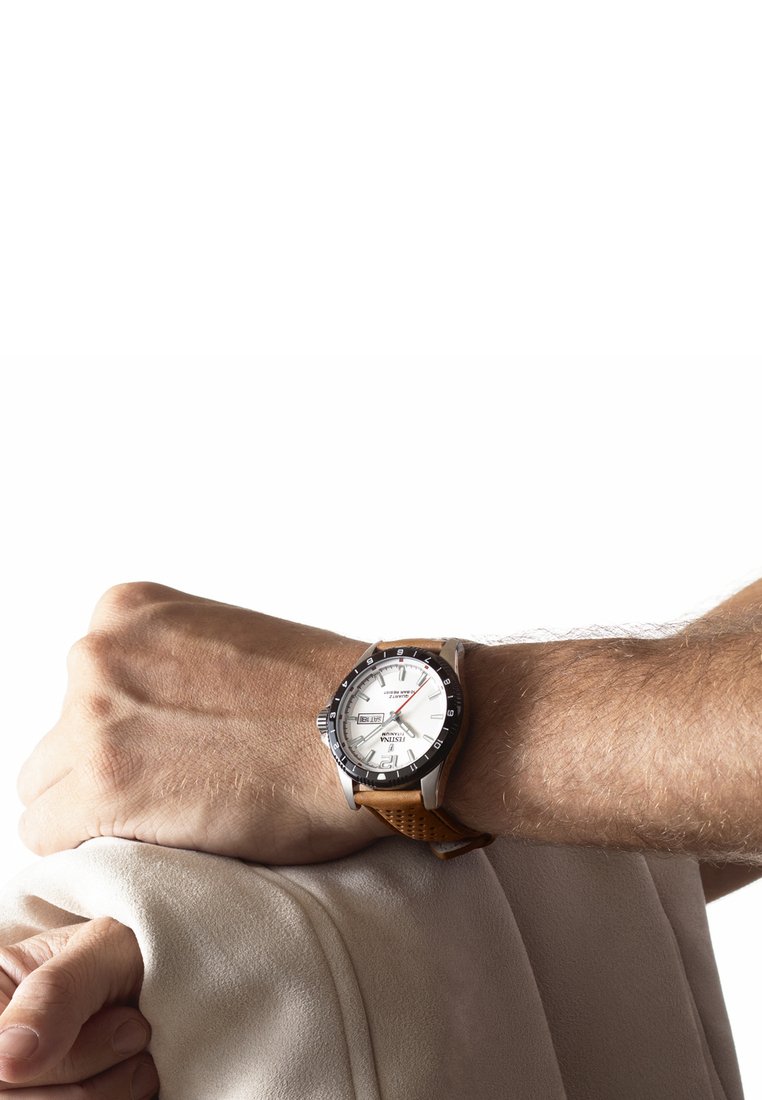 Silver och svart armbandsur med en vit urtavla, brunt läderarmband med perforeringar, som visar datum och veckodag.