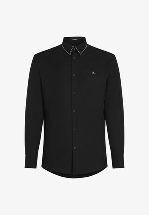 Camisa negra de manga larga hecha de una tela suave, que presenta un collar tipo button-down con acentos de brillantes y un logo sutil en el pecho.