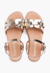Sandali metallici dorati con due larghe cinghie, un caratteristico elemento decorativo e una cinghia alla caviglia con fibbia su una comoda soletta beige.