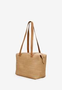 Bolso de paja tejido con asas de cuero, forma rectangular, superficie texturada y cierre con cremallera. Diseño minimalista sin patrones visibles.